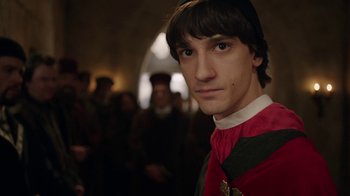 Movie still from “Knightfall” (2017), created by Richard Rayner – A man in a red and black shirt and a black hat; Close Up shot, Over the shoulder angle