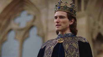 Movie still from “Knightfall” (2017), created by Richard Rayner – A man wearing a gold crown and a blue robe; Close Up shot, Over the shoulder angle