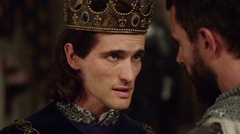 Movie still from “Knightfall” (2017), created by Richard Rayner – A person wearing a crown; Close Up shot, Over the shoulder angle