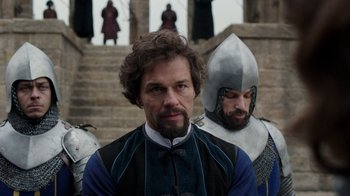 Movie still from “Knightfall” (2017), created by Richard Rayner – Two men in medieval garb standing next to each other; Medium shot, Over the shoulder angle