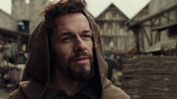 Movie still from “Knightfall” (2017), created by Richard Rayner – A man with a beard wearing a towel around his head; Close Up shot, Low angle