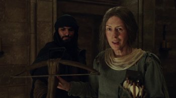 Movie still from “Knightfall” (2017), created by Richard Rayner – A man and a woman in medieval garb holding a bow; Medium shot, Over the shoulder angle