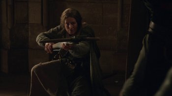 Movie still from “Knightfall” (2017), created by Richard Rayner – A woman is holding a sword in a room; Medium shot, Over the shoulder angle
