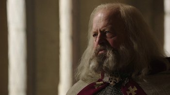 Movie still from “Knightfall” (2017), created by Richard Rayner – An old man with long white hair and a beard; Close Up shot, Over the shoulder angle