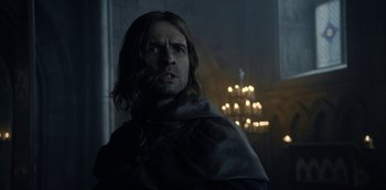 Movie still from “Knightfall” (2017), created by Richard Rayner – A person with long hair wearing a cape; Close Up shot, Low angle