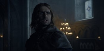 Movie still from “Knightfall” (2017), created by Richard Rayner – A person wearing a cape; Close Up shot, Low angle