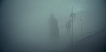 Movie still from “La Révolution” (2020), directed by Jérémie Rozan – Two people are hugging in the fog; Wide shot, Low angle