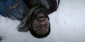 Movie still from “Black Summer” (2019), created by John Hyams – A man laying in the snow with his mouth open; Close Up shot, Overhead angle