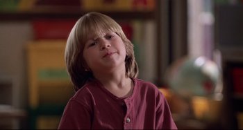 Movie still from “Liar Liar” (1997), directed by Tom Shadyac – A young boy with long blond hair wearing a red shirt; Close Up shot, Low angle