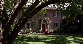 Movie still from “Liar Liar” (1997), directed by Tom Shadyac – Two people sitting in front of a pink house; Extreme Wide shot, High angle