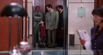 Movie still from “Liar Liar” (1997), directed by Tom Shadyac – A group of people standing in a room; Medium shot, Over the shoulder angle