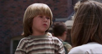 Movie still from “Liar Liar” (1997), directed by Tom Shadyac – A young boy with blonde hair and a striped shirt; Close Up shot, Over the shoulder angle