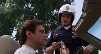 Movie still from “Liar Liar” (1997), directed by Tom Shadyac – A police officer is holding a knife to a man's face; Close Up shot, Over the shoulder angle