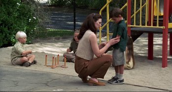 Movie still from “Liar Liar” (1997), directed by Tom Shadyac – A woman kneeling down next to a young boy; Wide shot, Over the shoulder angle