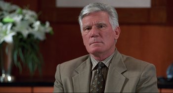 Movie still from “Liar Liar” (1997), directed by Tom Shadyac – An older man wearing a suit and tie; Close Up shot, High angle