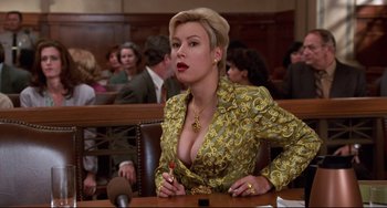 Movie still from “Liar Liar” (1997), directed by Tom Shadyac – A woman sitting at a table in front of a crowd; Medium shot, Low angle