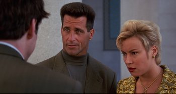 Movie still from “Liar Liar” (1997), directed by Tom Shadyac – A man and a woman standing next to each other in front of a building; Close Up shot, Over the shoulder angle