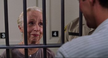 Movie still from “Liar Liar” (1997), directed by Tom Shadyac – An older woman sitting behind bars in a jail cell; Close Up shot, Over the shoulder angle