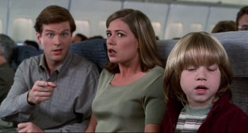 Movie still from “Liar Liar” (1997), directed by Tom Shadyac – Three people on an air plane looking surprised; Medium shot, High angle
