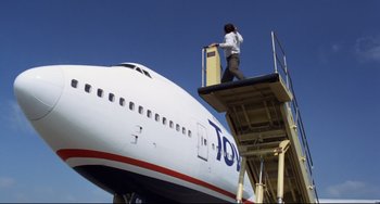 Movie still from “Liar Liar” (1997), directed by Tom Shadyac – A man standing on the side of an air plane; Extreme Wide shot, Low angle