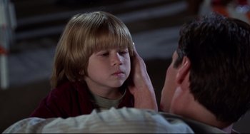 Movie still from “Liar Liar” (1997), directed by Tom Shadyac – A young boy holding his hand up to his ear; Close Up shot, Over the shoulder angle