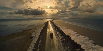 Movie still from “Locke & Key” (2020), created by Carlton Cuse – A truck driving down a road on a beach; Extreme Wide shot, High angle