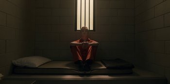 Movie still from “Locke & Key” (2020), created by Carlton Cuse – A man sitting on a bench in a jail cell; Wide shot, High angle