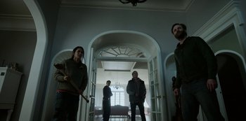 Movie still from “Black Summer” (2019), created by John Hyams – A group of people standing in a room holding weapons; Wide shot, Low angle