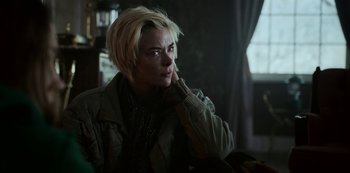 Movie still from “Black Summer” (2019), created by John Hyams – A woman with short blonde hair is sitting in a room; Close Up shot, Over the shoulder angle