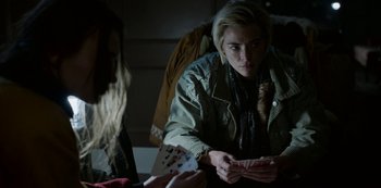 Movie still from “Black Summer” (2019), created by John Hyams – A woman sitting in front of another woman holding a deck of playing cards; Close Up shot, Over the shoulder angle