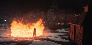 Movie still from “Locke & Key” (2020), created by Carlton Cuse – A person standing in front of a large fire; Extreme Wide shot, High angle