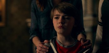 Movie still from “Locke & Key” (2020), created by Carlton Cuse – A young boy with his hands clasped together; Close Up shot, Over the shoulder angle