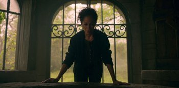 Movie still from “Locke & Key” (2020), created by Carlton Cuse – A woman standing in front of an open window; Medium shot, Low angle