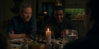 Movie still from “Locke & Key” (2020), created by Carlton Cuse – Two men sitting at a table with a lit candle; Medium shot, Over the shoulder angle