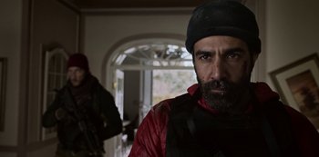 Movie still from “Black Summer” (2019), created by John Hyams – A man with a beard wearing a red jacket and a black hat; Close Up shot, Over the shoulder angle