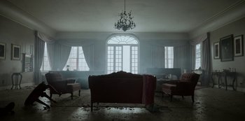 Movie still from “Black Summer” (2019), created by John Hyams – A living room filled with furniture and a chandelier; Extreme Wide shot, Low angle