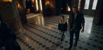 Movie still from “Locke & Key” (2020), created by Carlton Cuse – A man and a woman are walking in a room; Wide shot, High angle