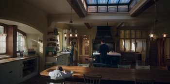 Movie still from “Locke & Key” (2020), created by Carlton Cuse – Two people are in a kitchen with a fireplace; Wide shot, High angle