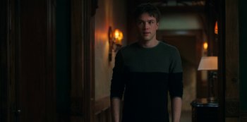 Movie still from “Locke & Key” (2020), created by Carlton Cuse – A man standing in front of a wall with a light on; Medium shot, Over the shoulder angle