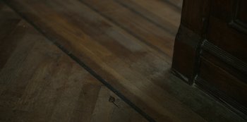 Movie still from “Locke & Key” (2020), created by Carlton Cuse – A wooden floor that has a key on it; Extreme Close Up shot, High angle