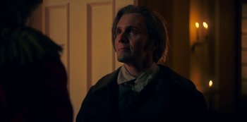 Movie still from “Locke & Key” (2020), created by Carlton Cuse – A man with long blonde hair wearing a suit and tie; Close Up shot, Over the shoulder angle