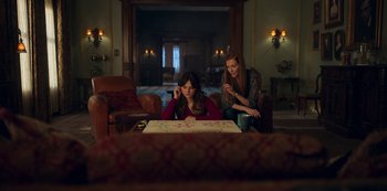 Movie still from “Locke & Key” (2020), created by Carlton Cuse – Two women sitting at a table in a living room; Medium shot, High angle