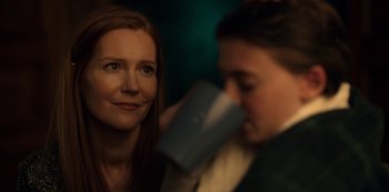 Movie still from “Locke & Key” (2020), created by Carlton Cuse – A woman looking at the camera while a man drinks from a cup; Close Up shot, Over the shoulder angle