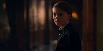 Movie still from “Locke & Key” (2020), created by Carlton Cuse – A young man in a black suit standing in front of a window; Close Up shot, Over the shoulder angle