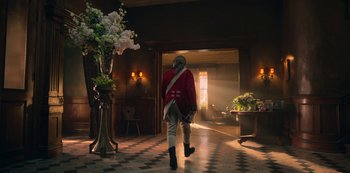 Movie still from “Locke & Key” (2020), created by Carlton Cuse – A man in a red jacket walking in a room; Wide shot, Low angle