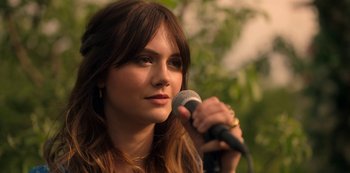 Movie still from “Locke & Key” (2020), created by Carlton Cuse – A beautiful young lady holding a microphone and looking to her left; Close Up shot, Over the shoulder angle