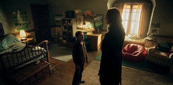Movie still from “Locke & Key” (2020), created by Carlton Cuse – A woman and a boy standing in a living room; Wide shot, High angle