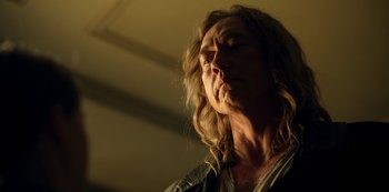 Movie still from “Locke & Key” (2020), created by Carlton Cuse – A man with long hair is blowing a kiss to the side; Close Up shot, Low angle