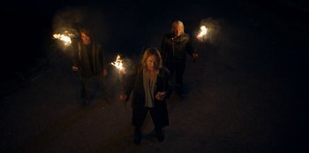 Movie still from “Locke & Key” (2020), created by Carlton Cuse – A group of people standing next to each other holding torches; Wide shot, High angle