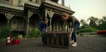 Movie still from “Locke & Key” (2020), created by Carlton Cuse – A woman and a young boy looking into an old trunk; Medium shot, Low angle